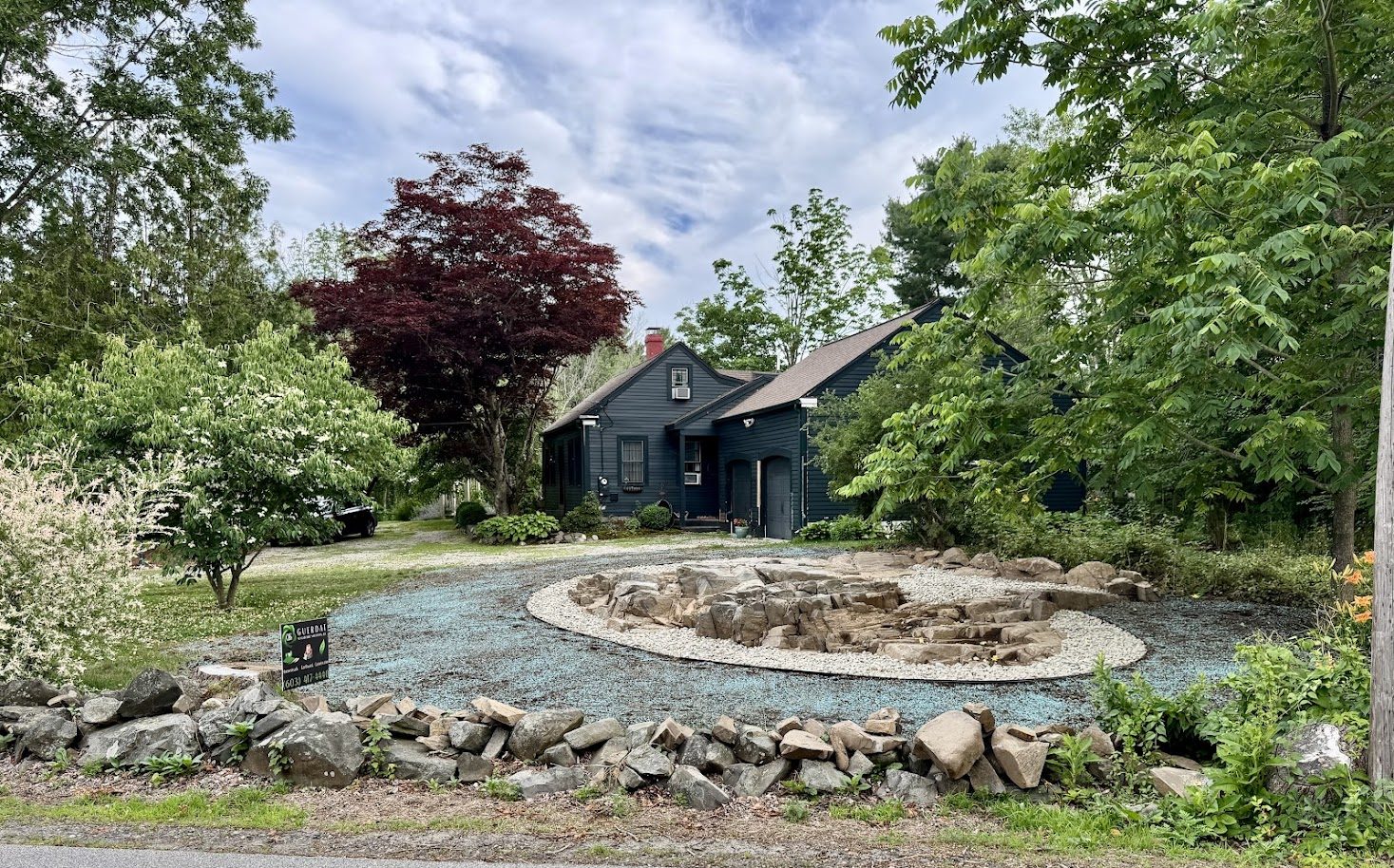 Circular stone driveway feature with cobble border at a navy Cape home, GSS New Hampshire
