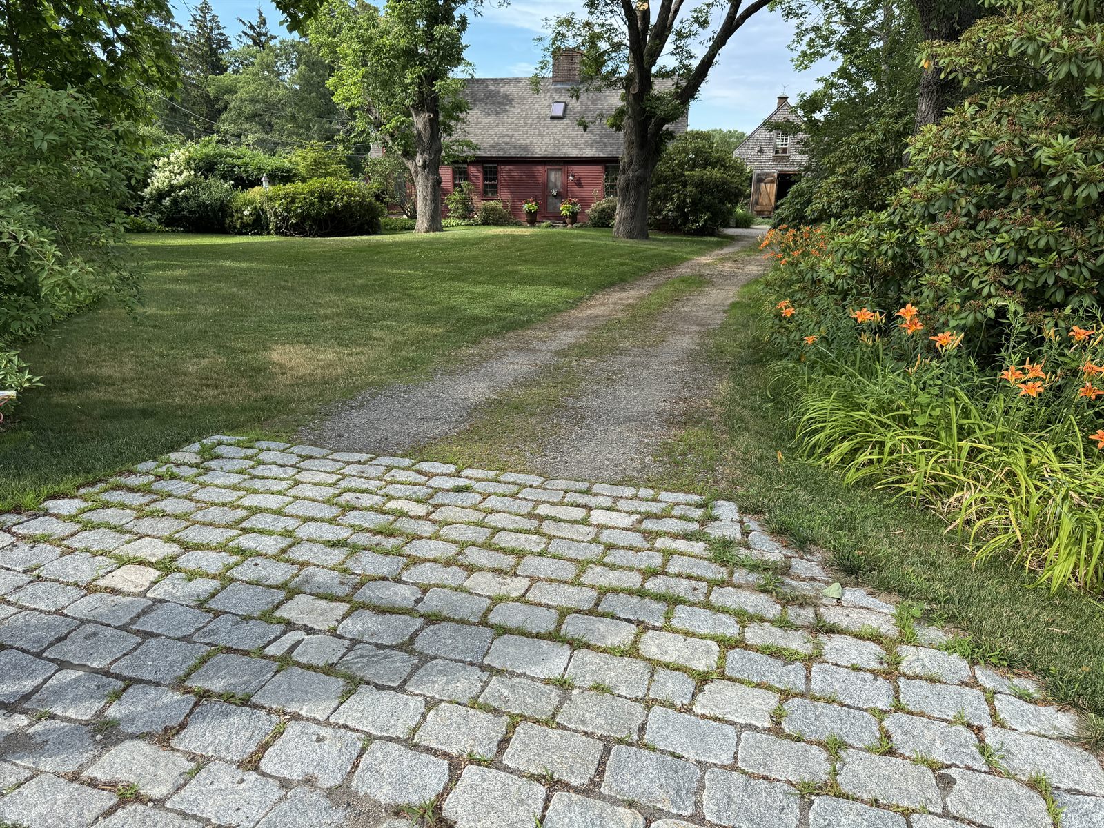 Granite cobble apron meeting a finished gravel drive — GSS, NH
