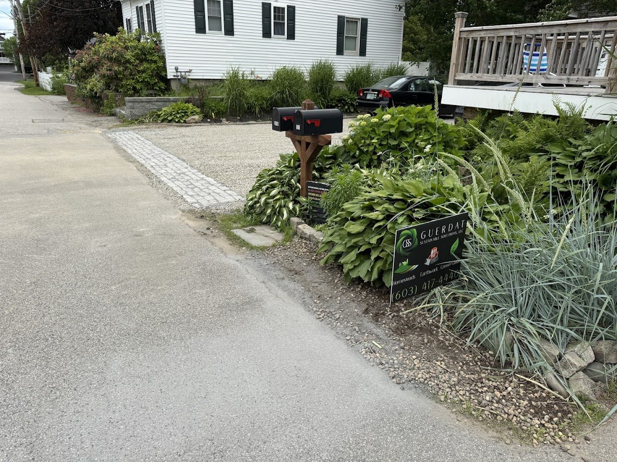 Granite cobble apron at the road edge with GSS yard sign and lush hosta plantings, GSS driveway, Seacoast NH