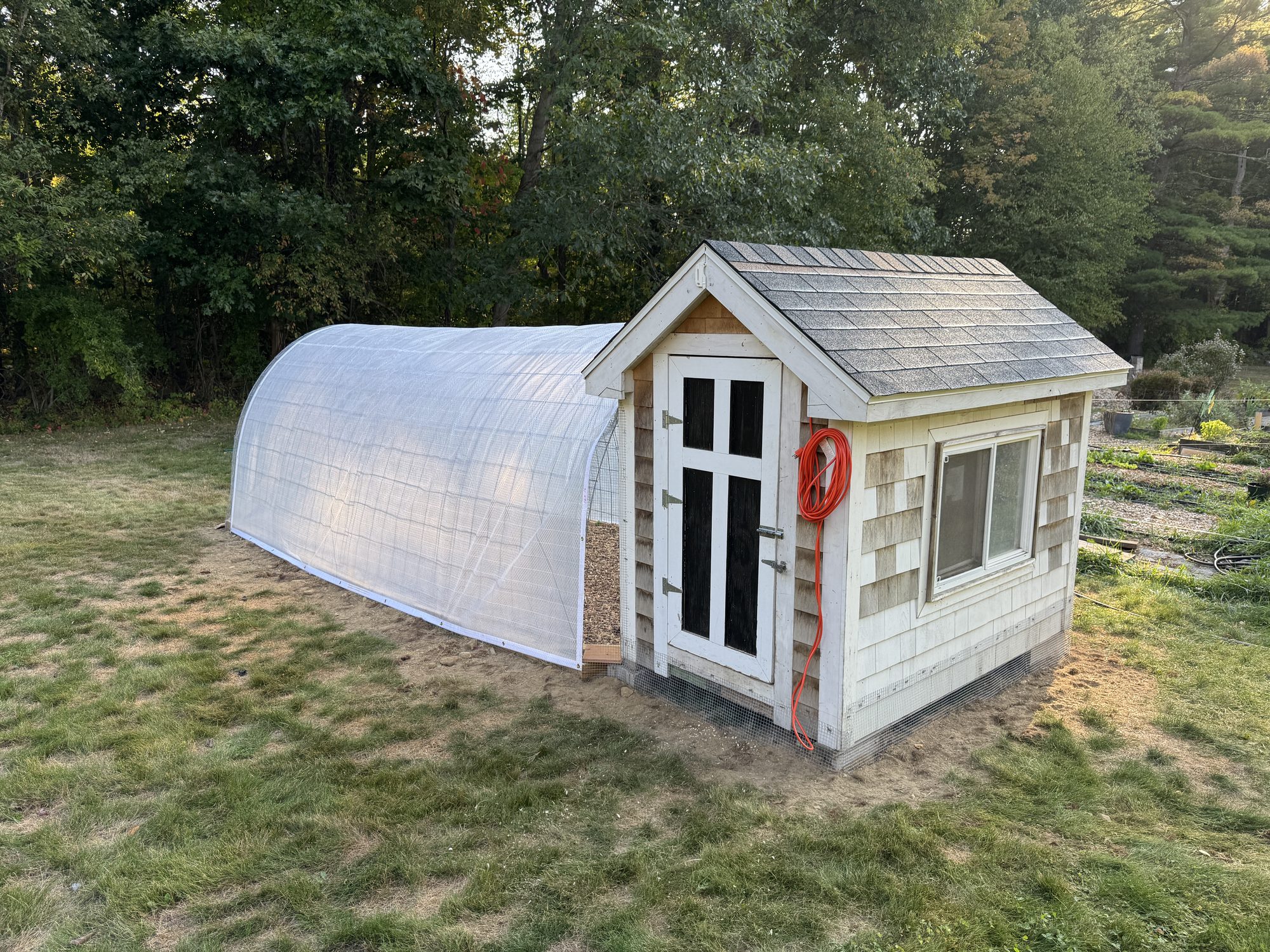 Custom hoop greenhouse attached to a cedar-shingled cottage shed, GSS greenhouse build