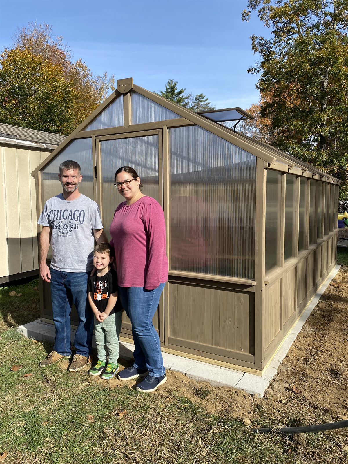 A family in front of their finished GSS-built greenhouse — Newfields, NH