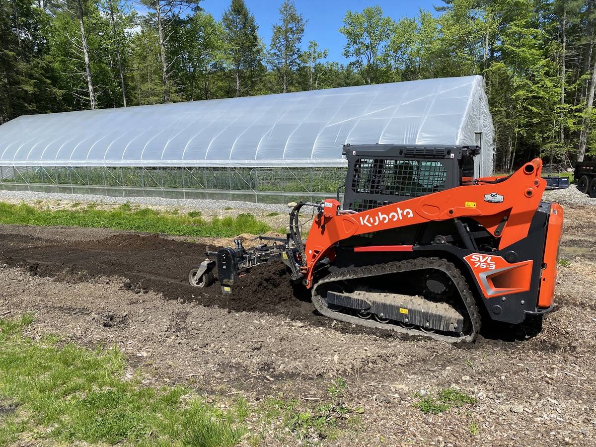 Skid steer working at a greenhouse site — GSS Landcrafting