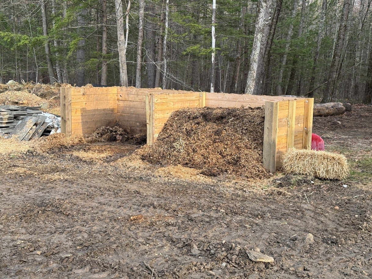 Multi-bay wooden compost system at different stages of decomposition, GSS Newfields NH